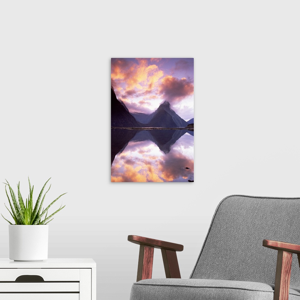 A modern room featuring Big, vertical photograph of Mitre Peak, reflecting in the still water of Milford Sound, as the su...