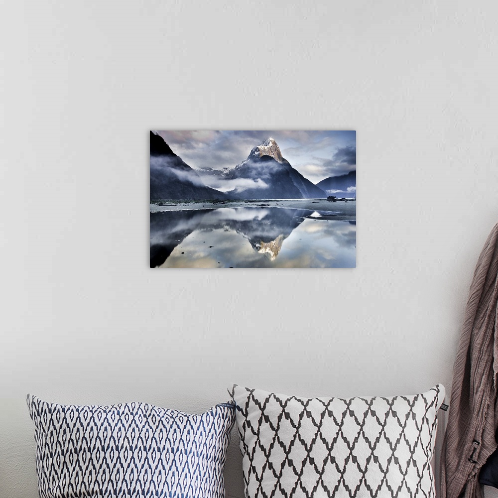 A bohemian room featuring A landscape photograph of a snow covered mountain peak and misty clouds reflecting in shallow bea...