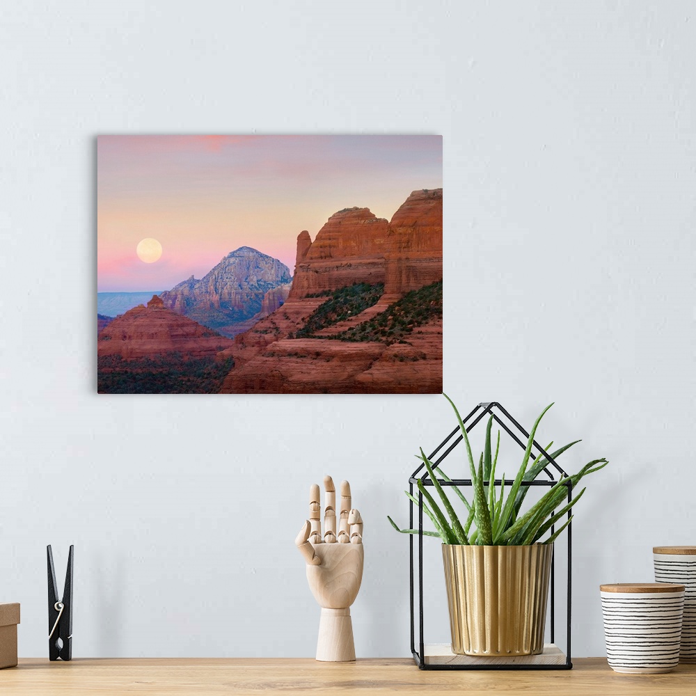 A bohemian room featuring Large, horizontal photograph of the moon setting in the early morning sky, over the large rock fo...