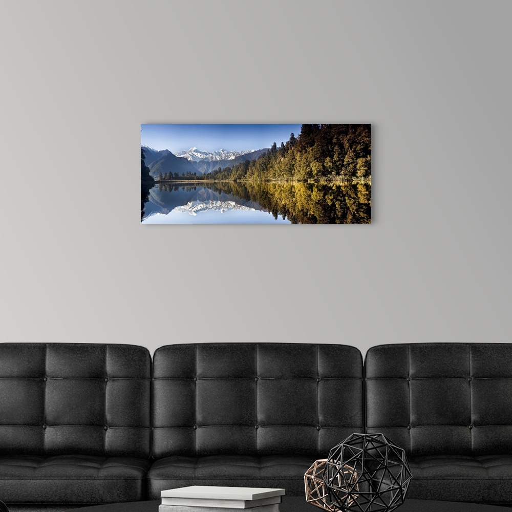 A modern room featuring Mount Cook and Mount Tasman reflected in Lake Matheson at sunset near Fox Glacier, New Zealand