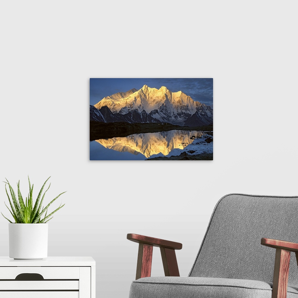 A modern room featuring Mt Makalu (8,462 meters) and Mt Chomolonzo (7,540 meters) bathed in dawn light, reflected in smal...
