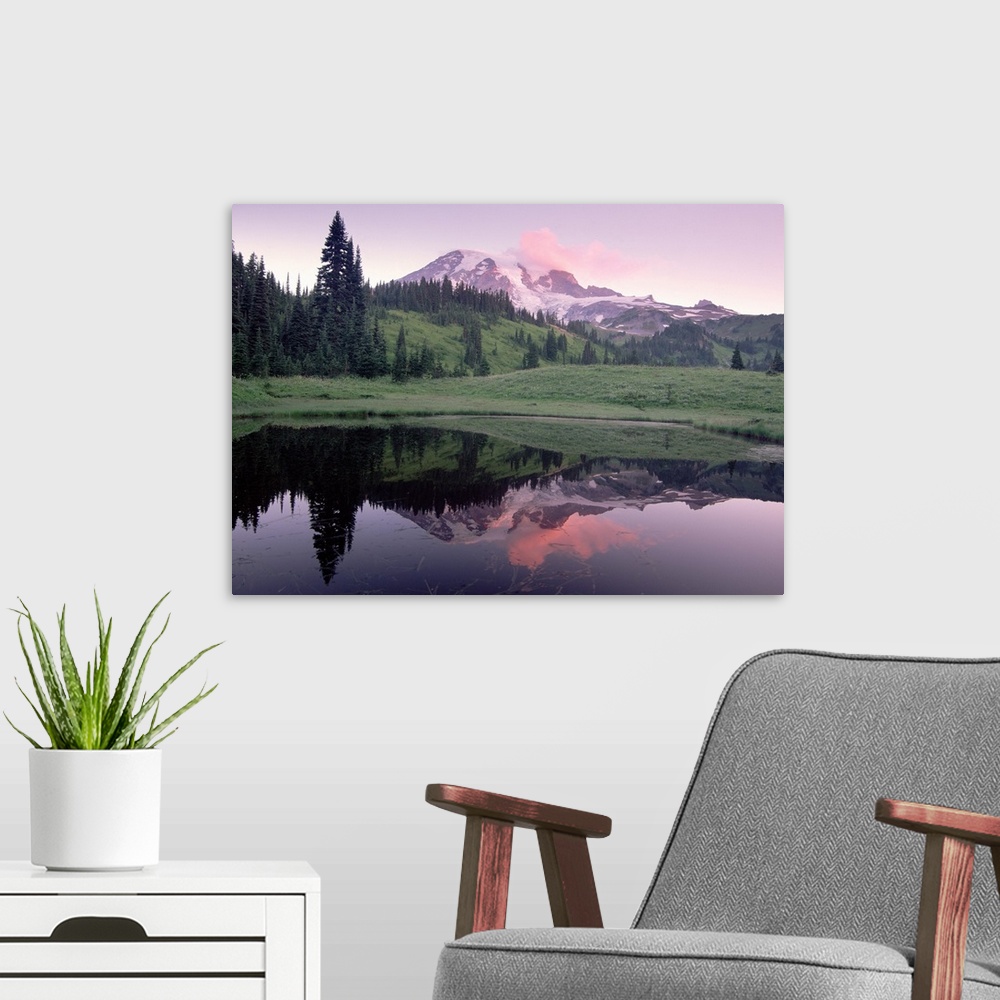 A modern room featuring Photograph of snow covered mountain and tree covered hills reflected in water below.