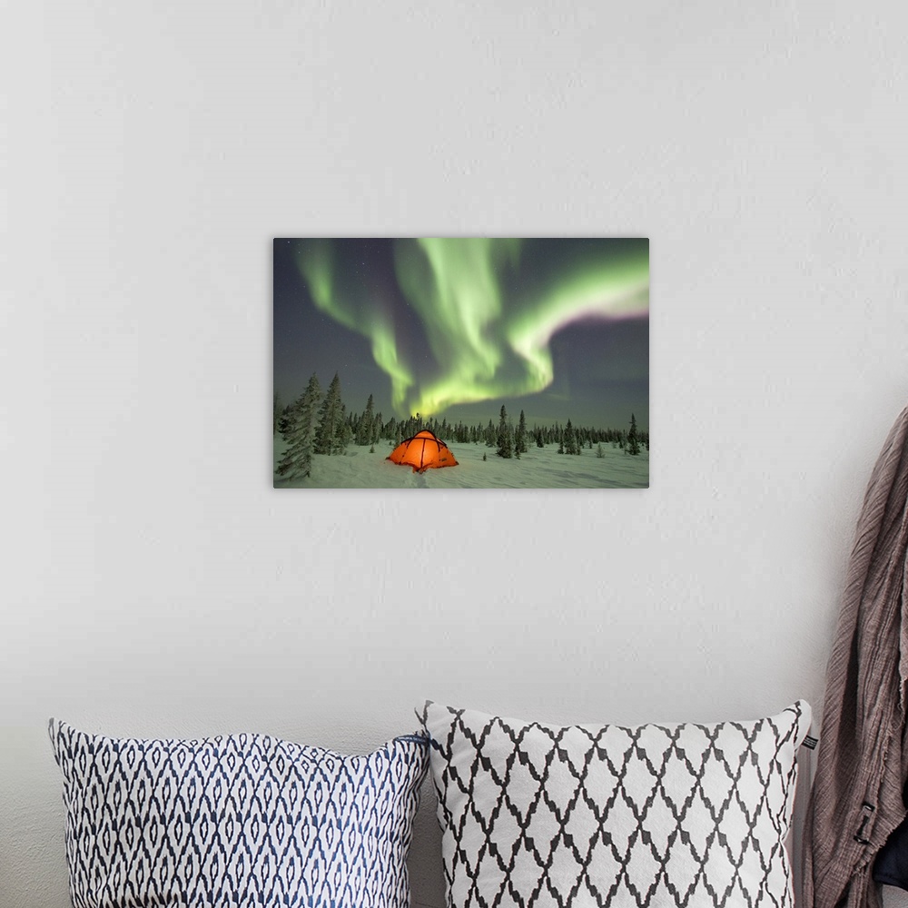 A bohemian room featuring This beautiful picture is taken of the northern lights over a campsite surrounded by snow covered...