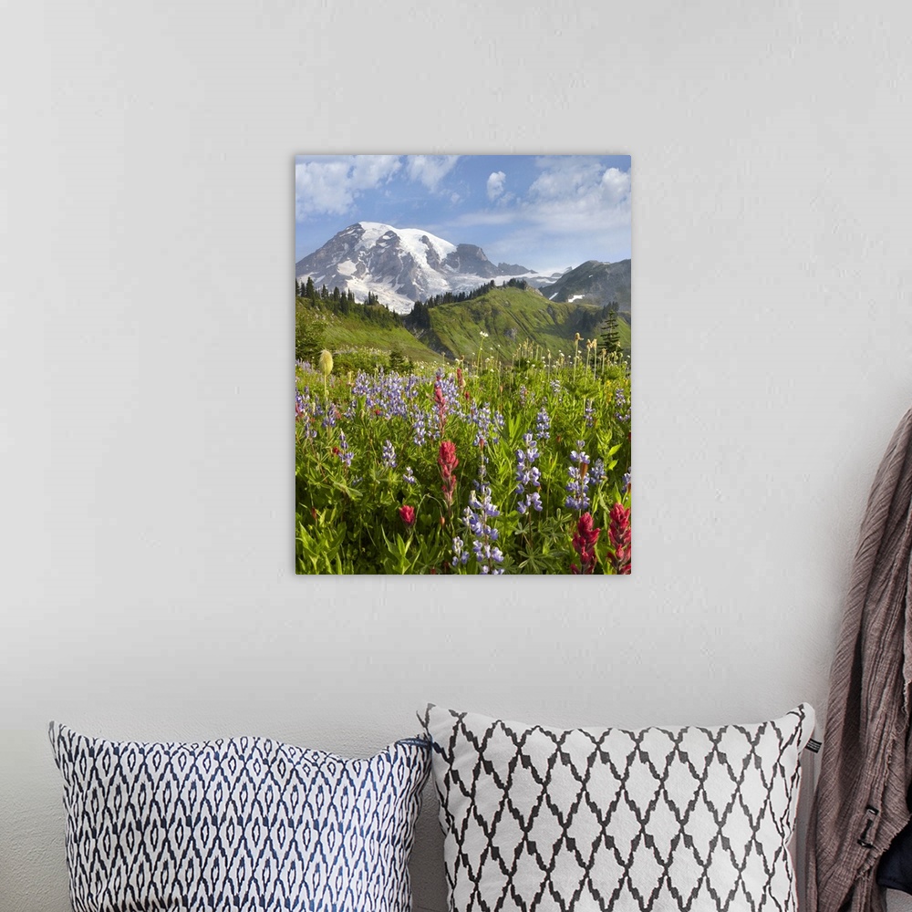 A bohemian room featuring A vertical photograph of a nature landscape filled with wildflowers in the foreground, trees grow...