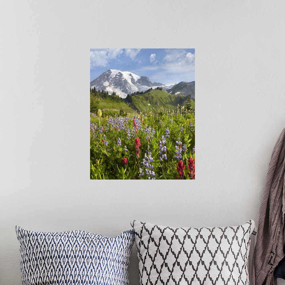 A bohemian room featuring A vertical photograph of a nature landscape filled with wildflowers in the foreground, trees grow...