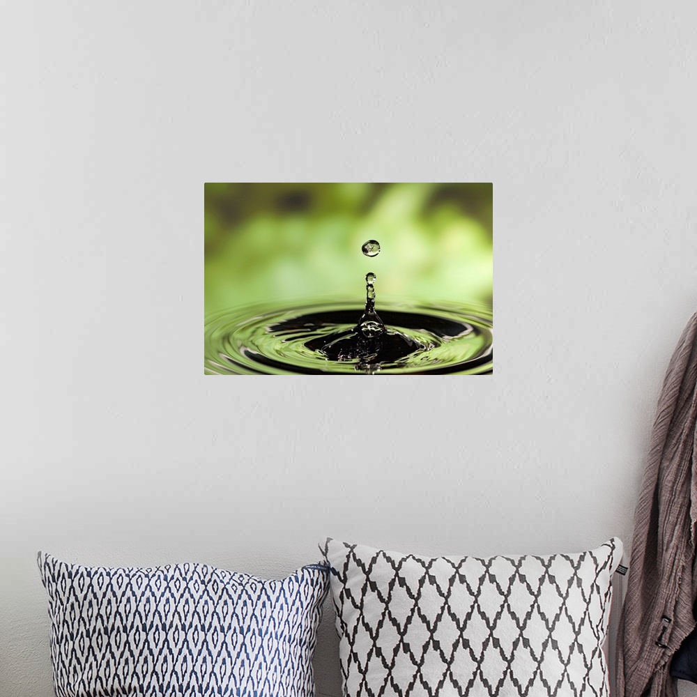 A bohemian room featuring Horizontal photograph of drop of water frozen in the air and rippling in the surface below.
