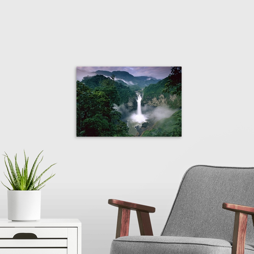 A modern room featuring Photograph of waterfall surrounded by rainforest with mountain silhouette in the distance.