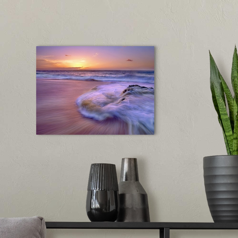 A modern room featuring Wall docor of waves rushing ashore on a beach with an Hawaiian sunset in the distance.