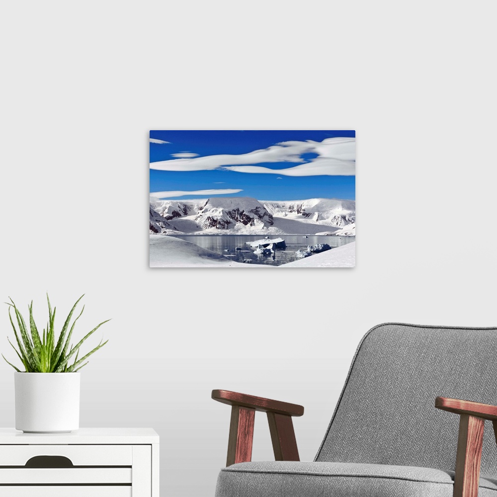 A modern room featuring Snow-covered mountains along coast, Antarctica.