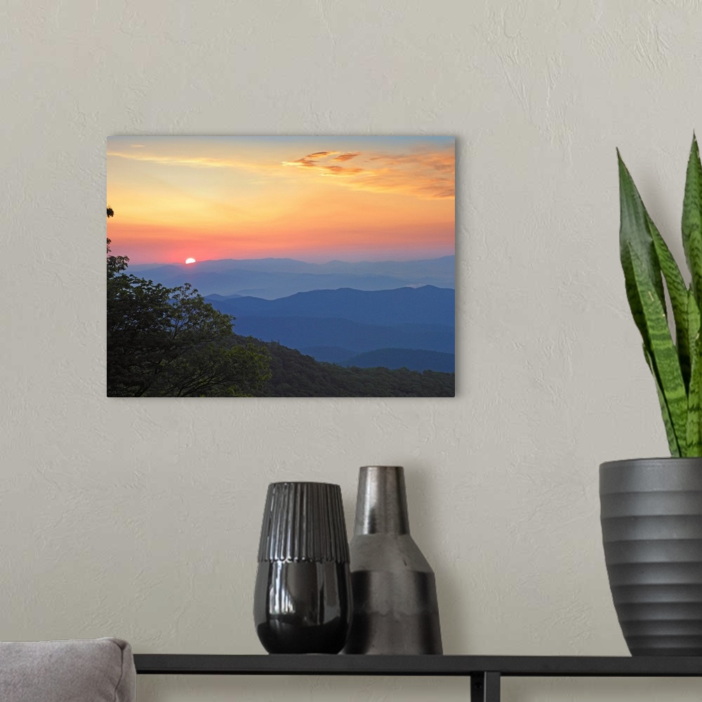 A modern room featuring Photo of the sun setting over the mountains from the Blue Ridge Parkway in North Carolina.