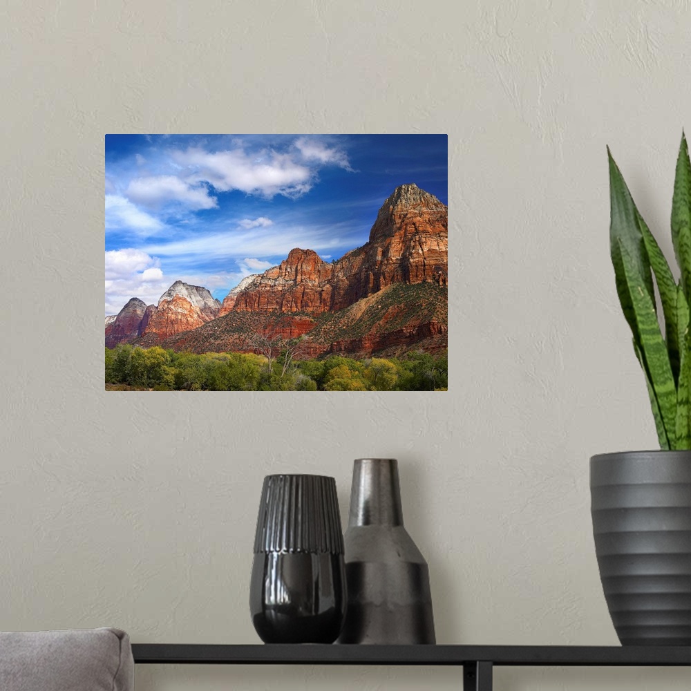 A modern room featuring Large photograph of canyon mountains and desert underbrush growth on a sunny day.