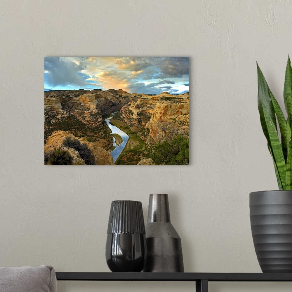 A modern room featuring High angle photograph of river flowing through canyon under a cloudy sky.