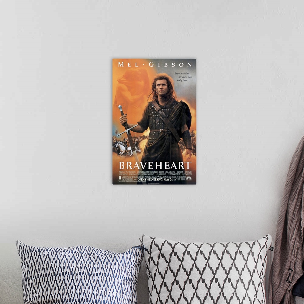 A bohemian room featuring Big, vertical movie advertisement on a wall hanging for Braveheart, Mel Gibson stands as a warrio...