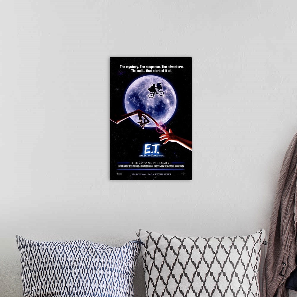 A bohemian room featuring A large vertical print of the 20th anniversary poster of E.T. It depicts the famous scene of the ...