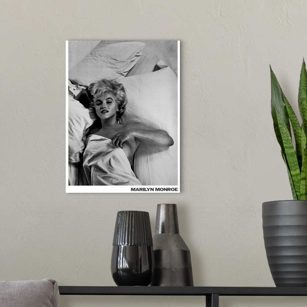 A modern room featuring Large monochromatic photograph shows a famous American actress, model, and singer laying in bed w...