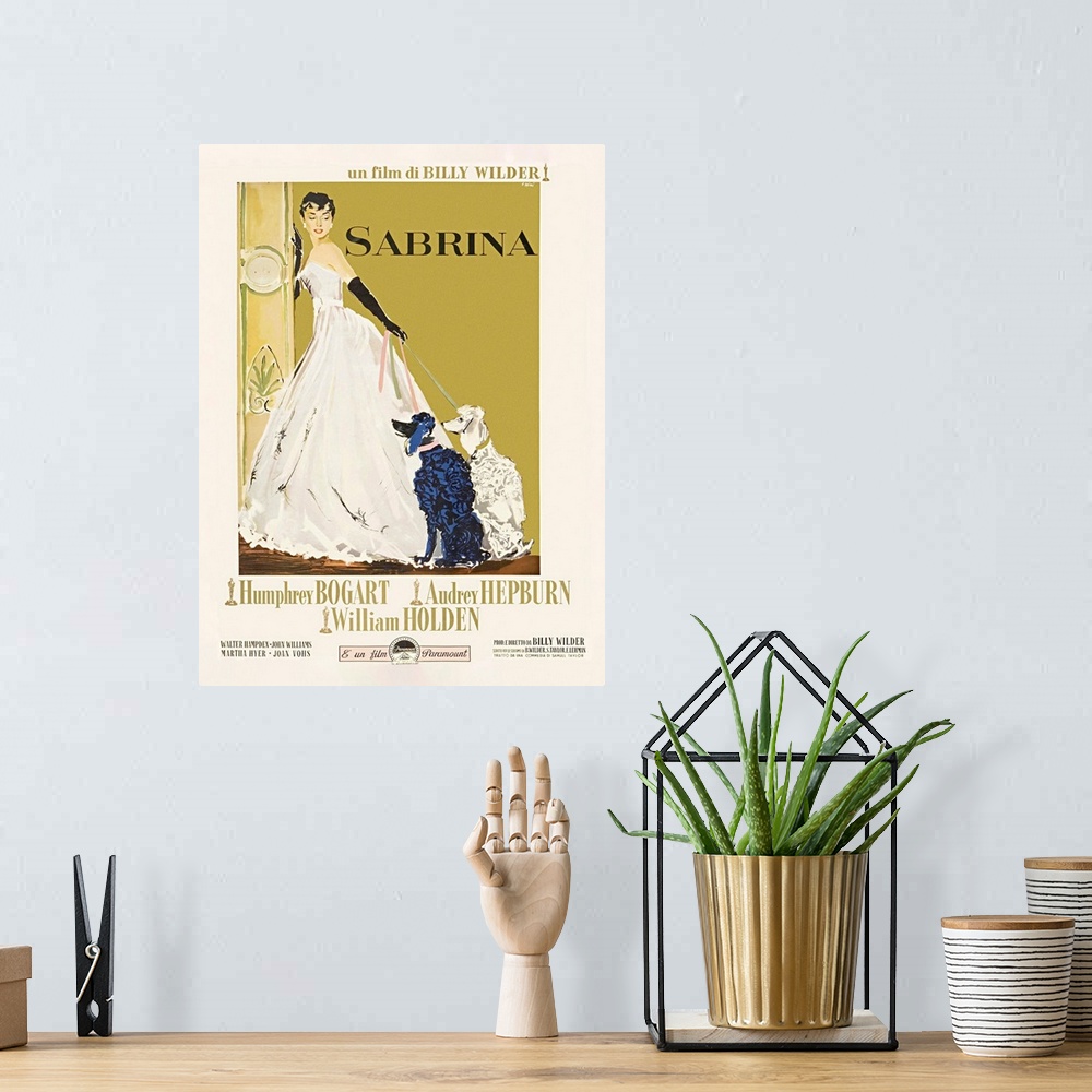 A bohemian room featuring Movie poster of the classic tale "Sabrina". It shows her in a white ball gown holding her two poo...