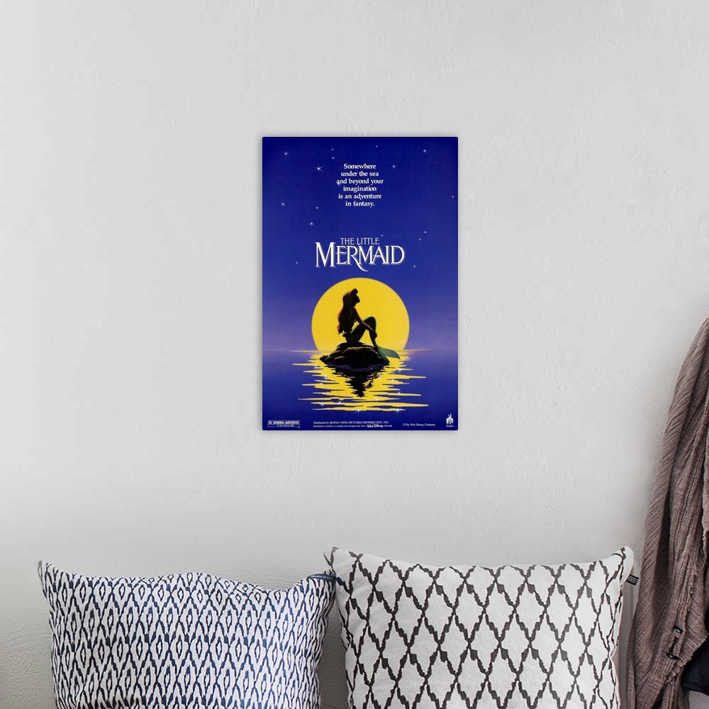 A bohemian room featuring Poster for the classic Disney movie "The Little Mermaid". Ariel sits on a rock in the ocean in fr...