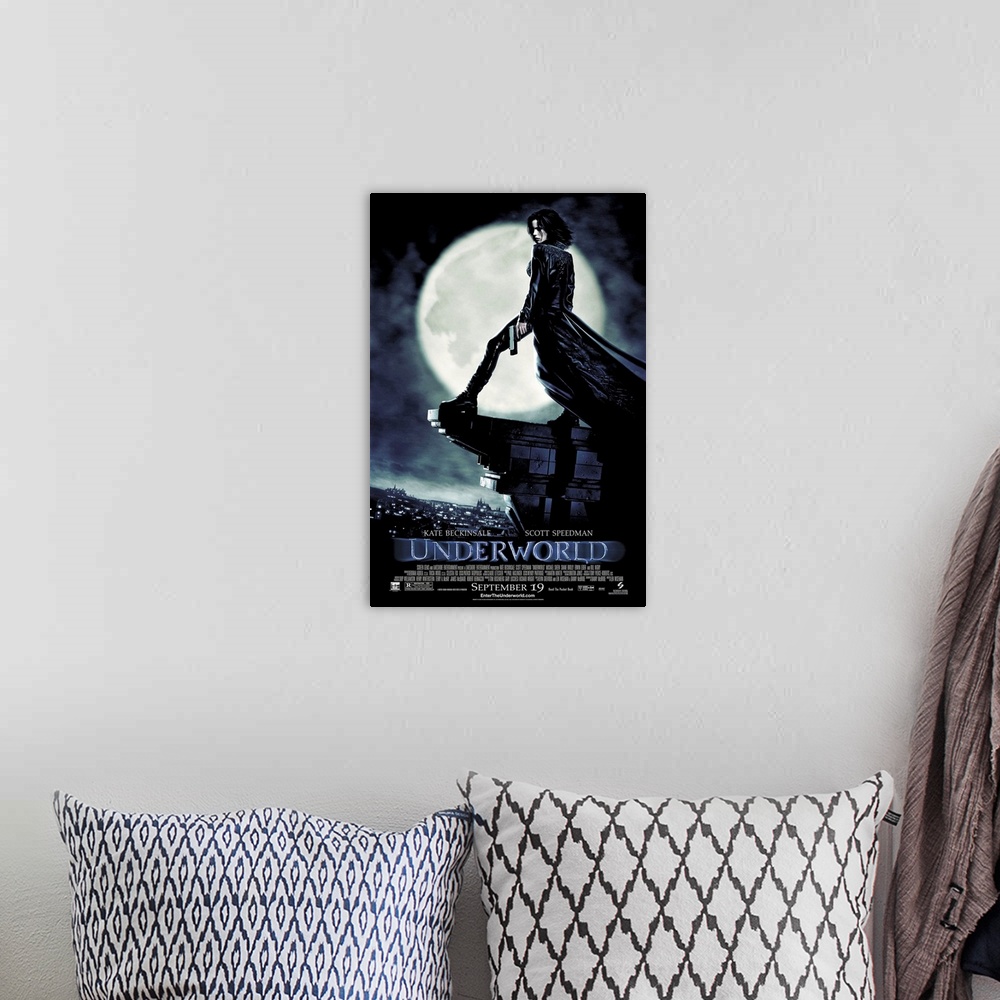 A bohemian room featuring Large, vertical movie advertisement for Underworld, main character Selene stands with a gun in he...