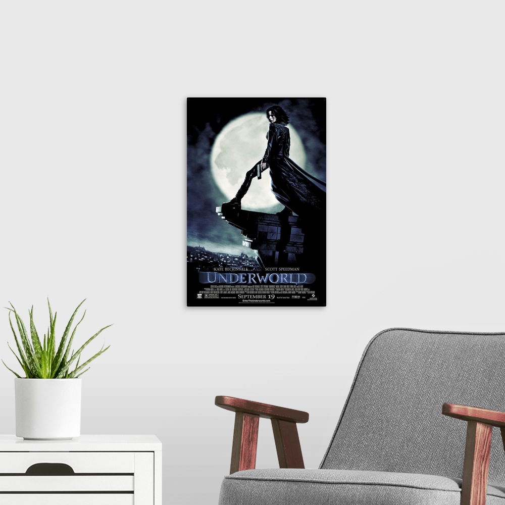 A modern room featuring Large, vertical movie advertisement for Underworld, main character Selene stands with a gun in he...