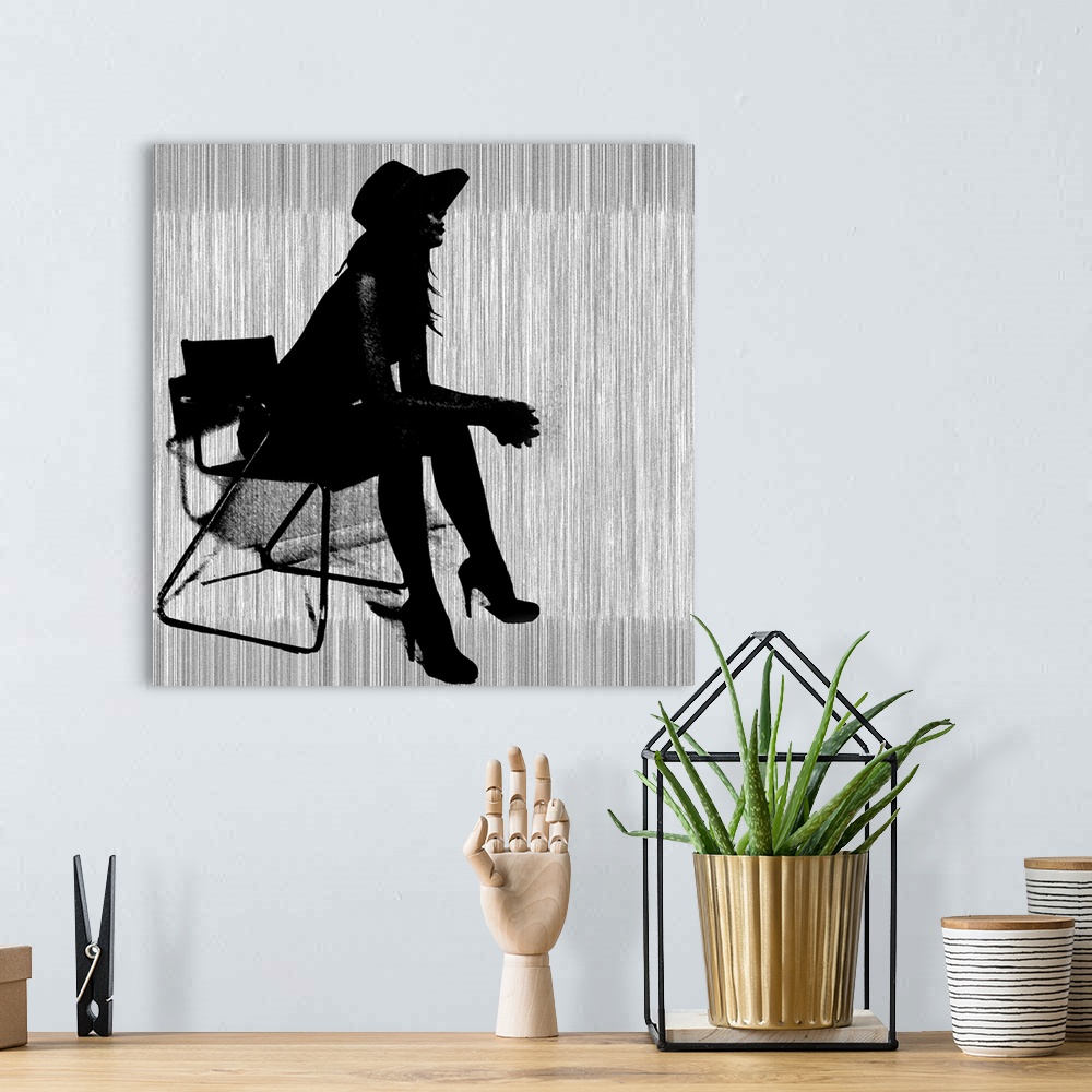 A bohemian room featuring Contemporary artwork of a silhouette of a woman wearing hills and a hat leaning forward in a chai...