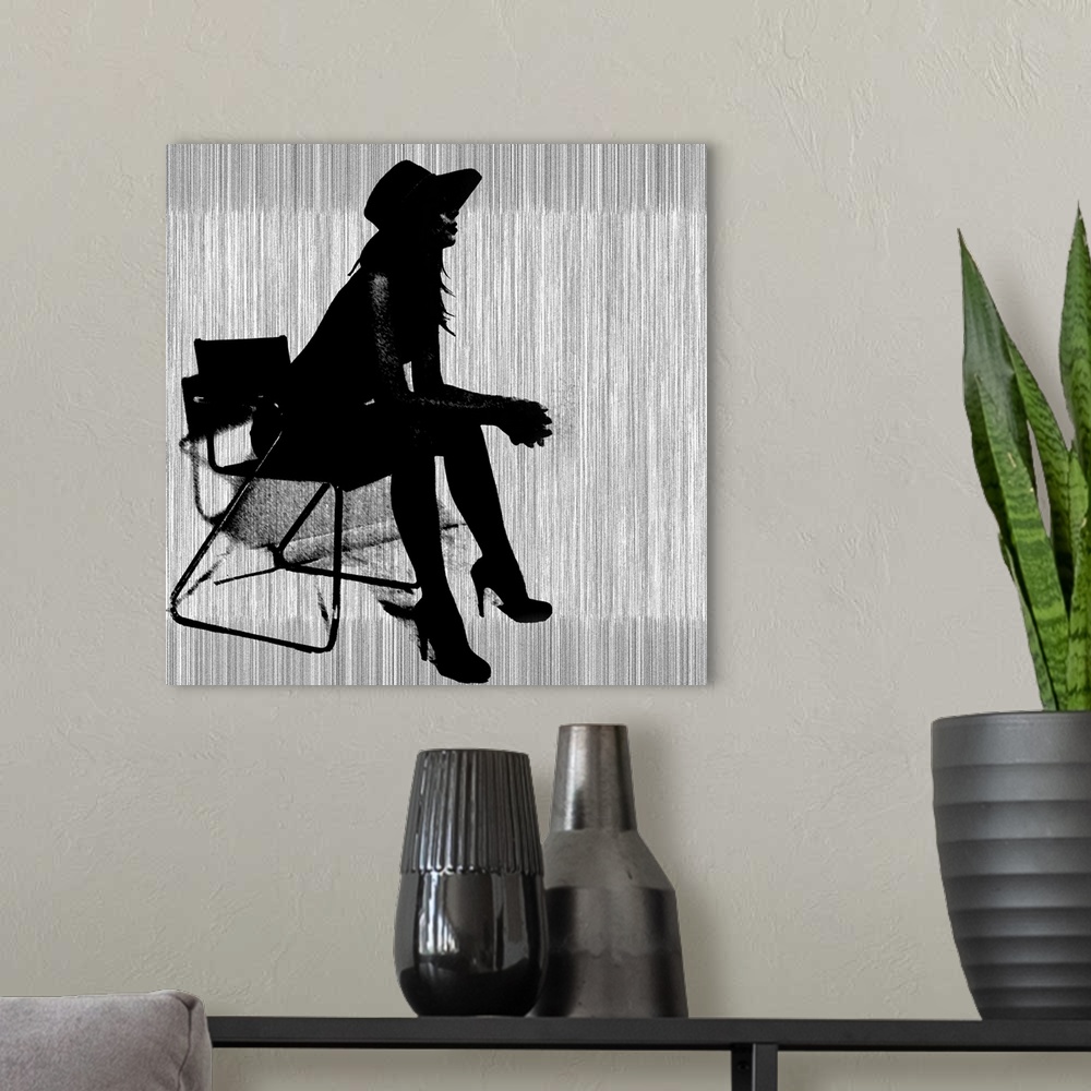 A modern room featuring Contemporary artwork of a silhouette of a woman wearing hills and a hat leaning forward in a chai...