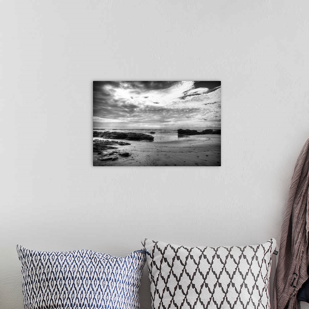 A bohemian room featuring Black and white photograph of a dramatic coastal scene.