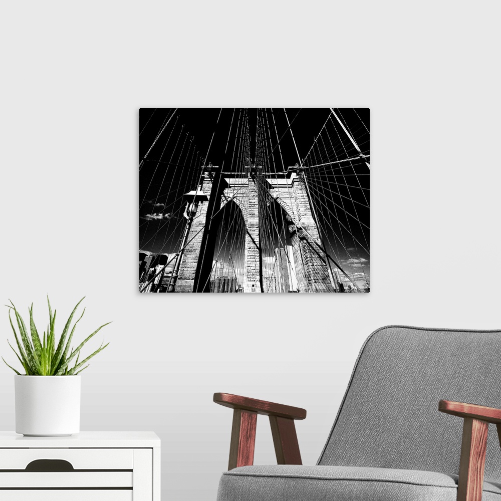 A modern room featuring Dramatic black and white photograph of the Brooklyn bridge arches and suspension cables.