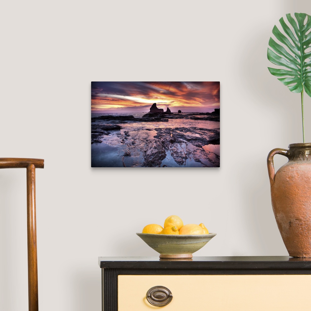 A traditional room featuring A photograph of a dramatic coastal sunset scene.