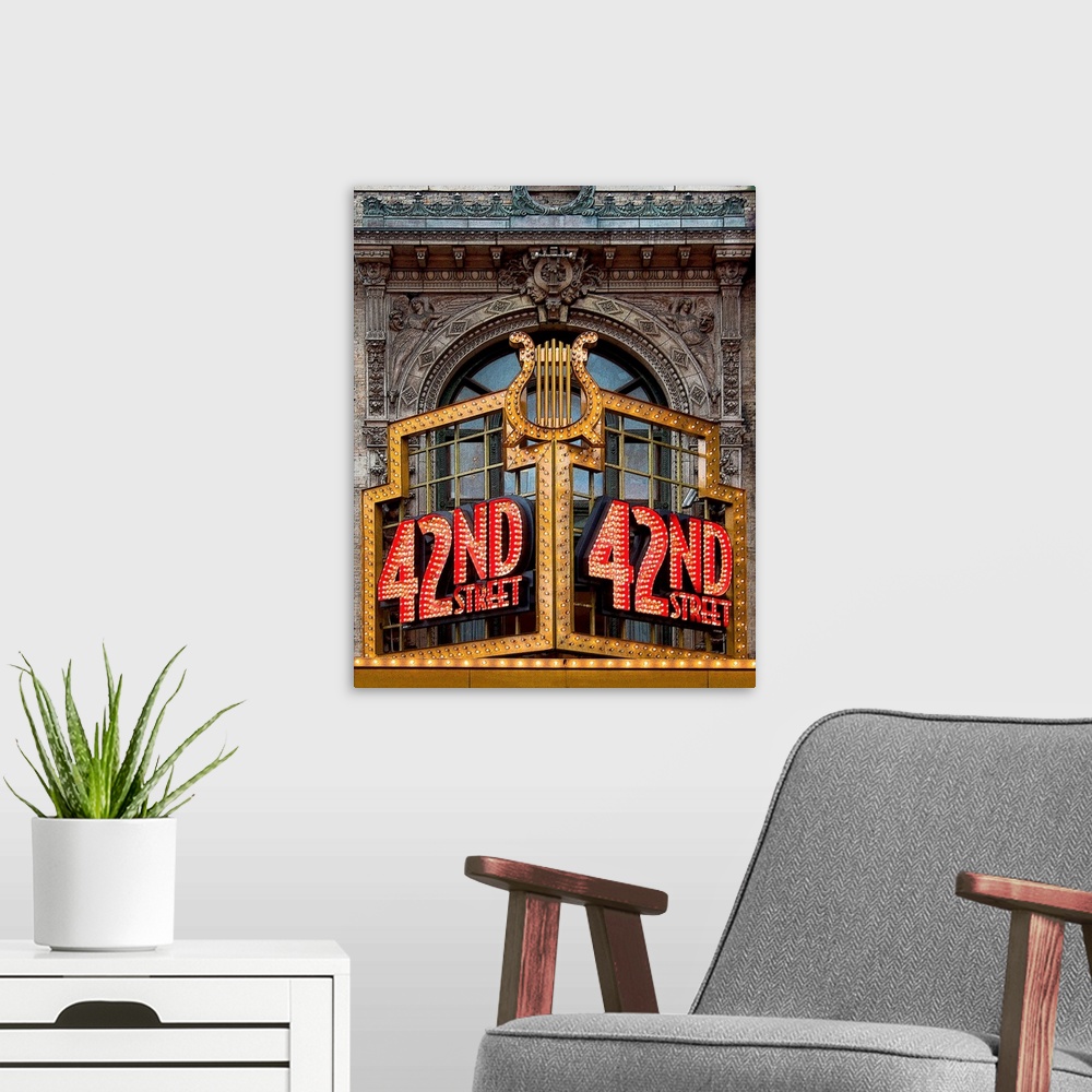 A modern room featuring Vibrant photograph of a lit up 42nd street sign on the facade of a building.