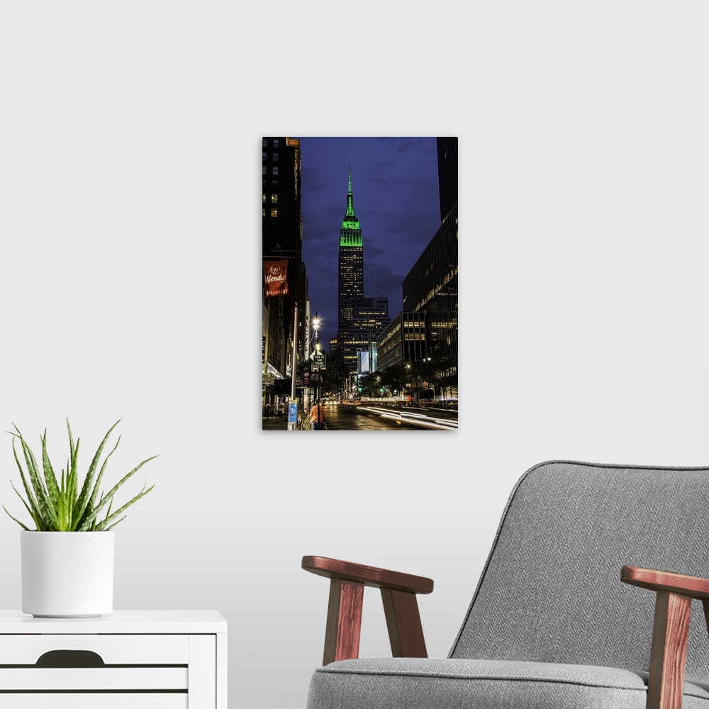 A modern room featuring A photograph of the Empire State Building with a green top at sunset.