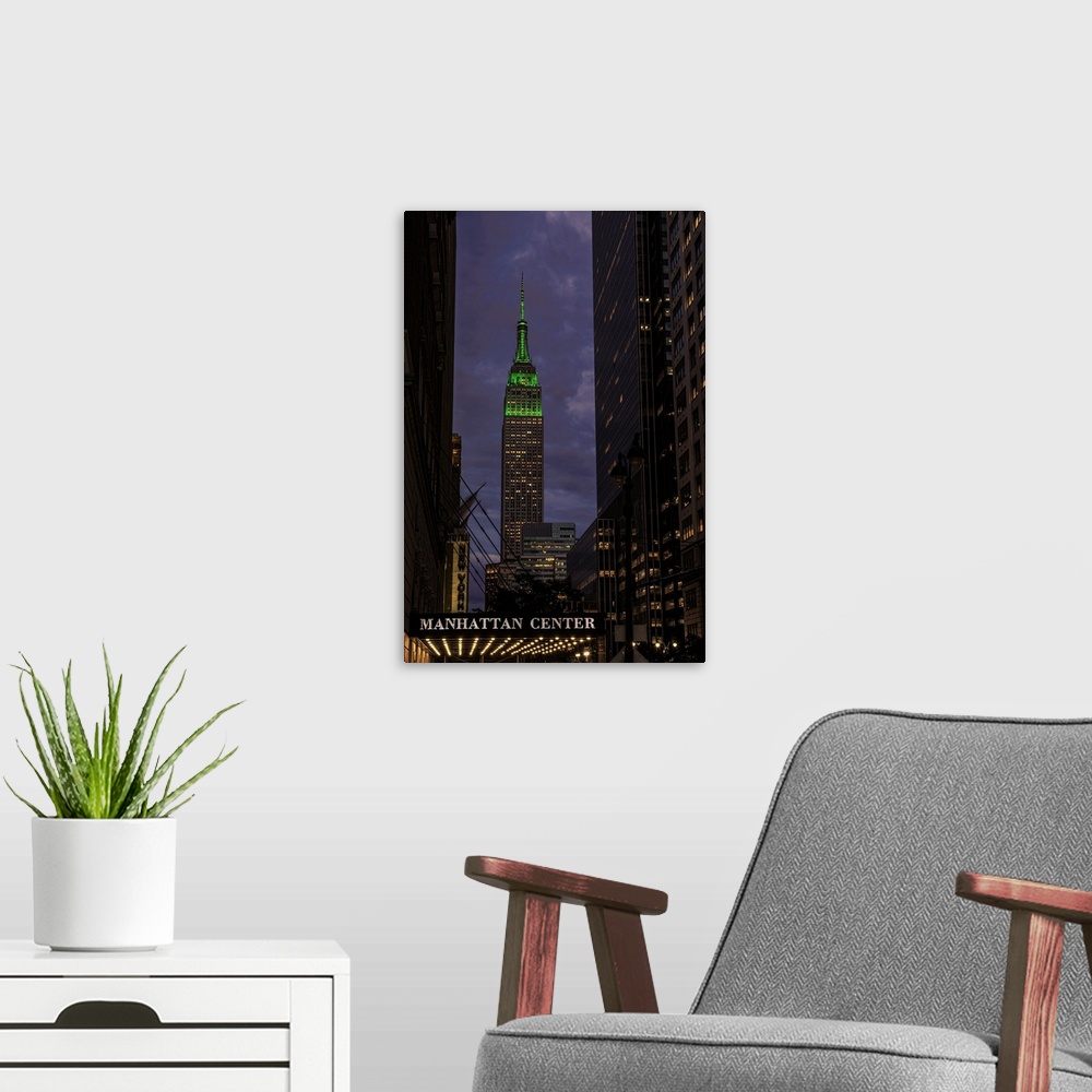 A modern room featuring A photograph of the Empire State Building with a green top at sunset.