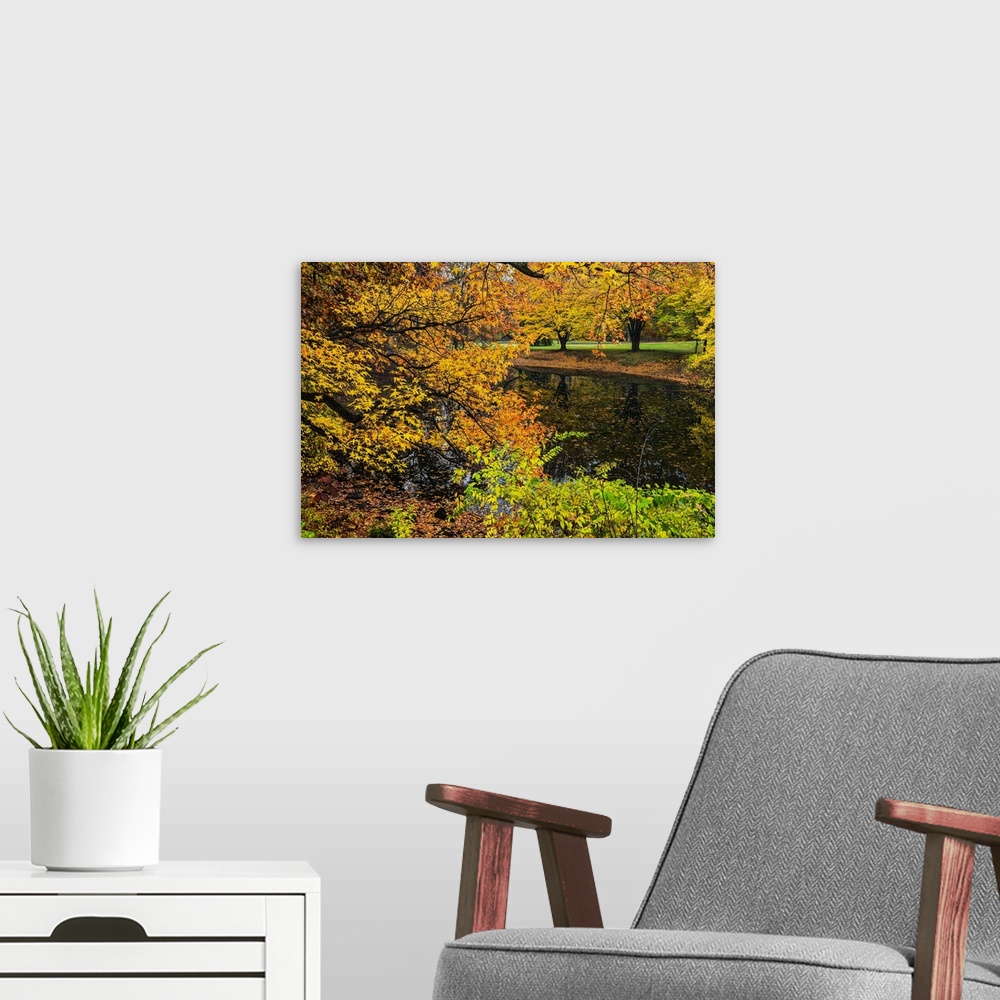 A modern room featuring A photograph of an idyllic countryside scene during fall.