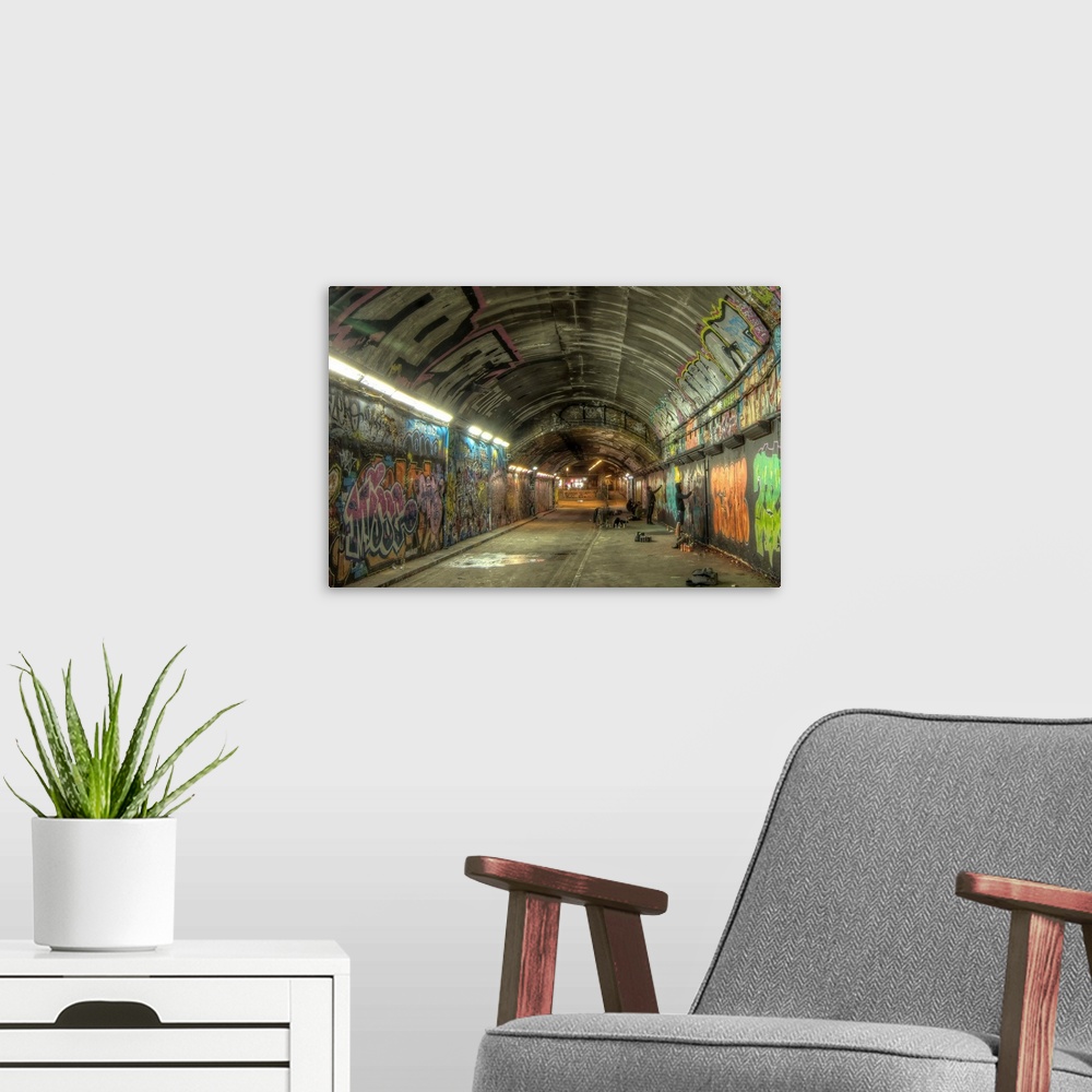 A modern room featuring HDR photograph of a tunnel with its walls filled with graffiti.