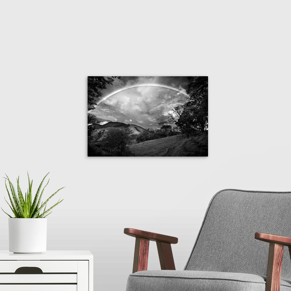 A modern room featuring Black and white photograph of a wilderness landscape with a large rainbow in the sky.