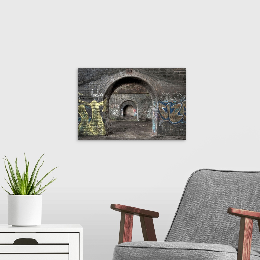 A modern room featuring HDR photograph of a tunnel with its walls filled with graffiti.