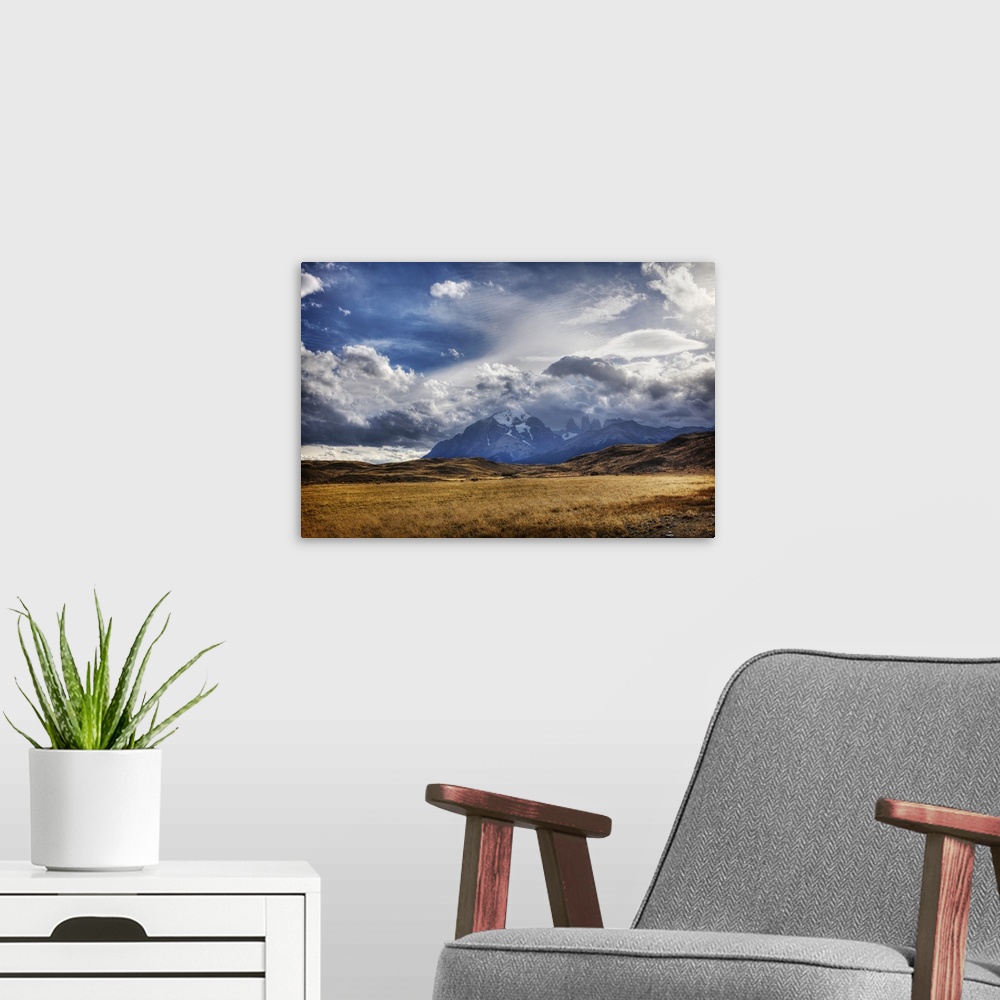 A modern room featuring Dramatic photograph of a clouds over a mountain range in the wilderness.