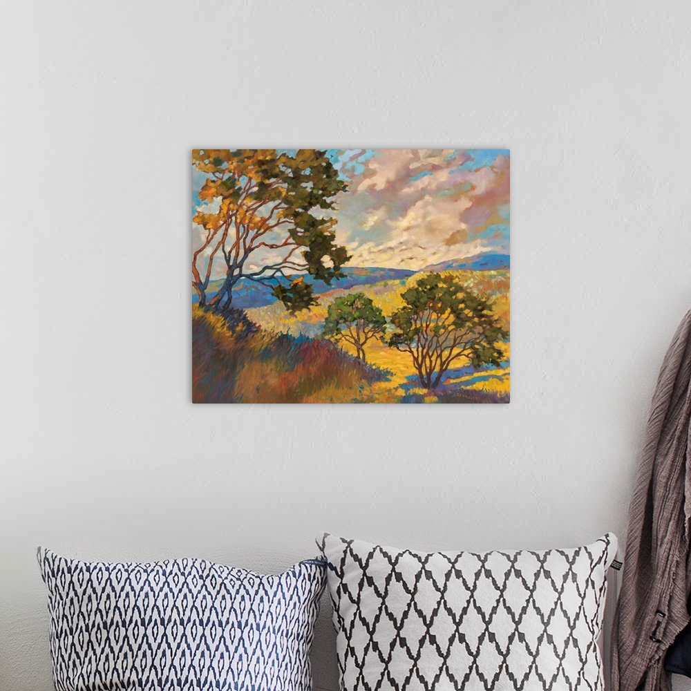A bohemian room featuring Contemporary landscape painting of trees in rolling yellow fields at sunset.