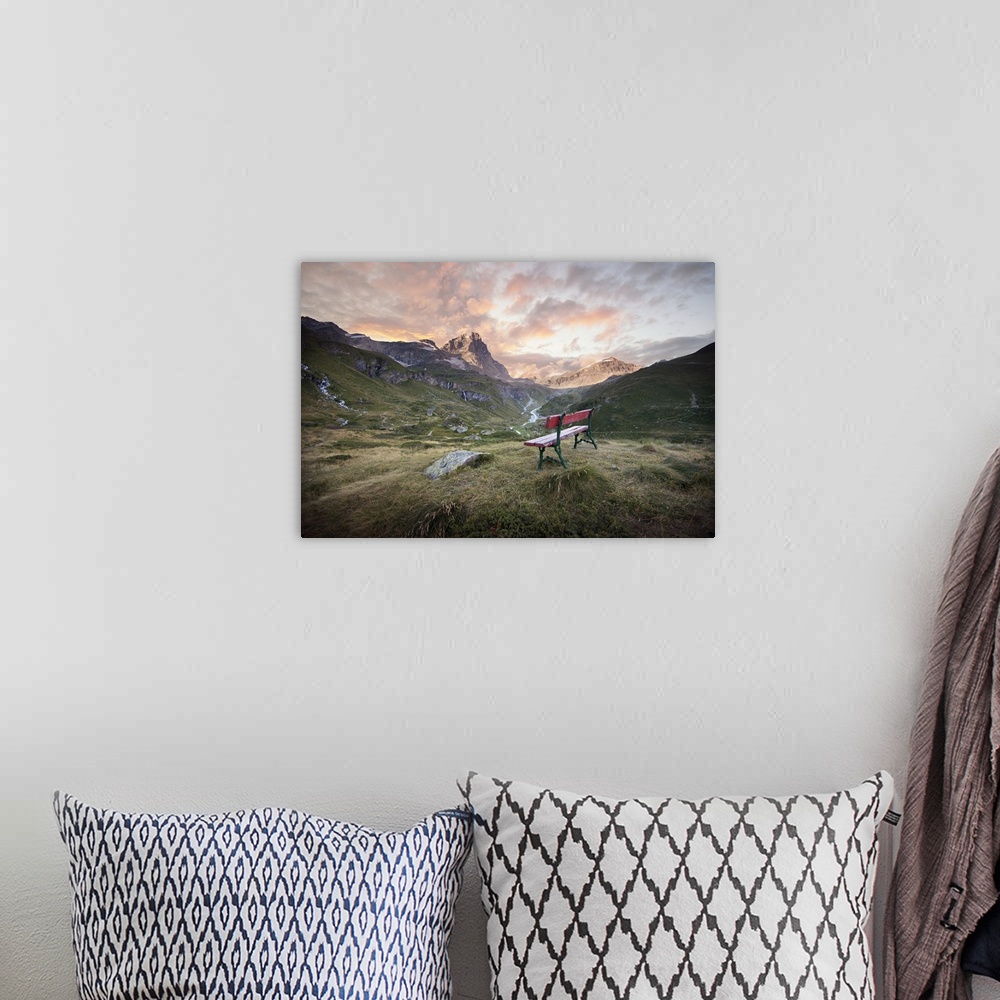 A bohemian room featuring Dramatic clouds over a mountain valley with a bench.