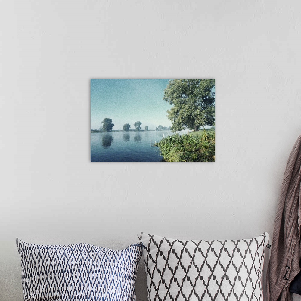 A bohemian room featuring Artistically grained photo. Early in the morning on the banks of a river. The rising sun dispelle...