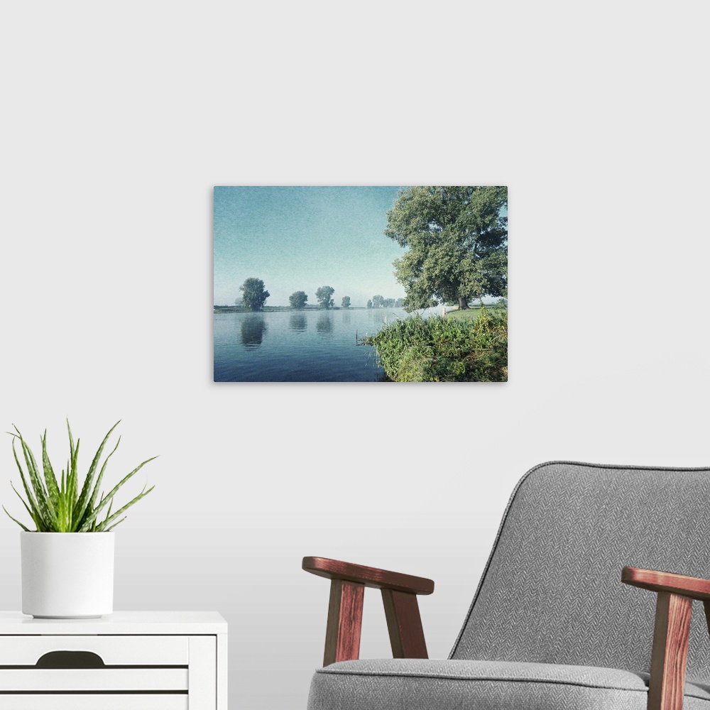 A modern room featuring Artistically grained photo. Early in the morning on the banks of a river. The rising sun dispelle...