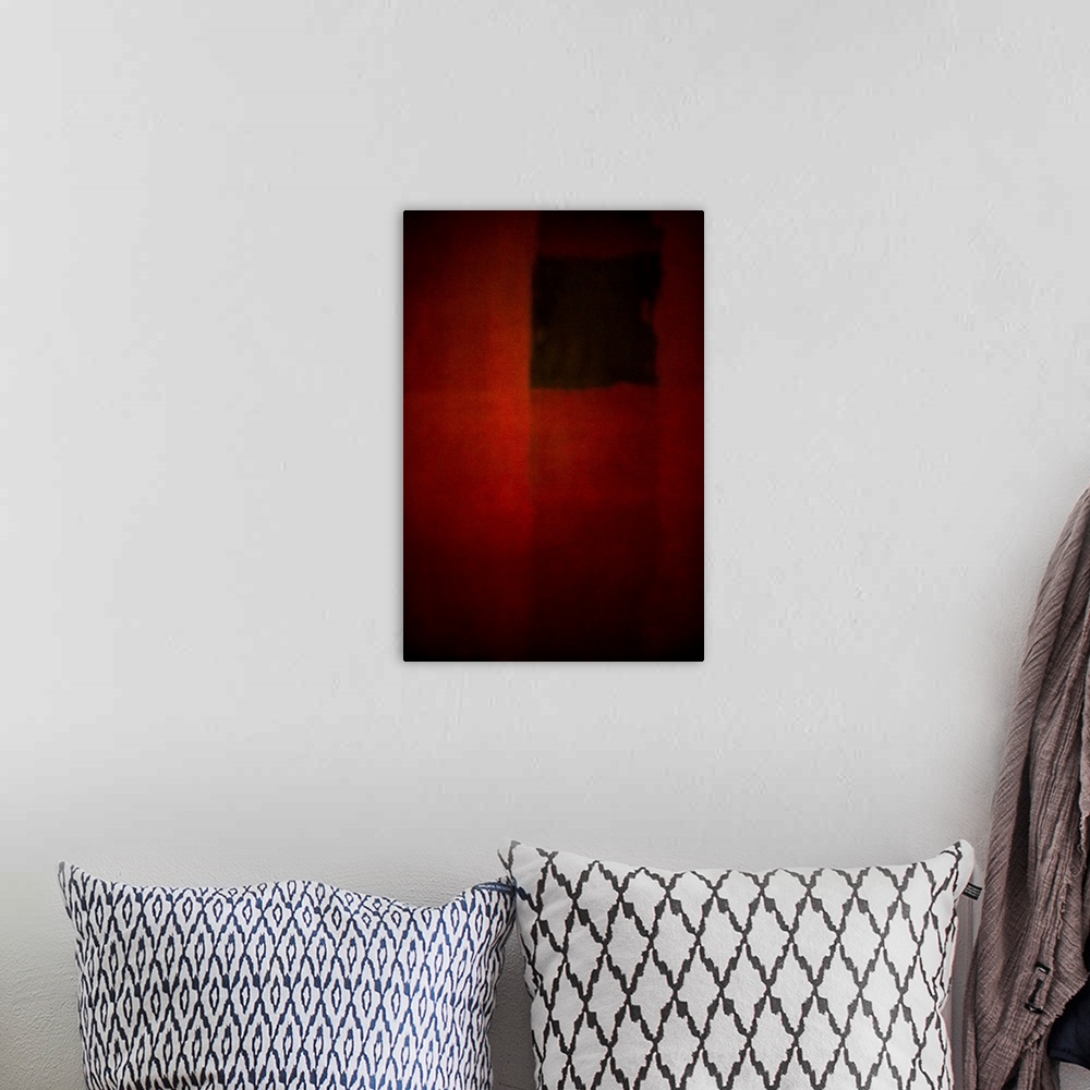 A bohemian room featuring Geometric abstract artwork that consists of deep reds and subtle polygonal shapes.