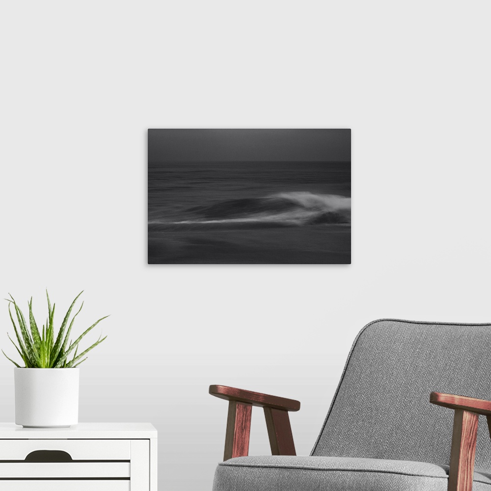 A modern room featuring Waves crashing on the shore in a silent lament on a cloudy dark evening.