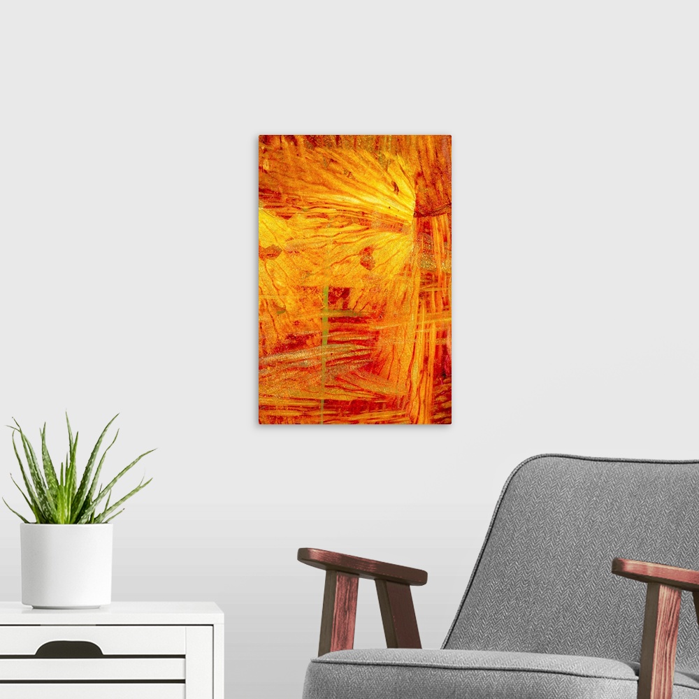 A modern room featuring Turbulent slices of reds and yellows fill the space in this abstract artwork.