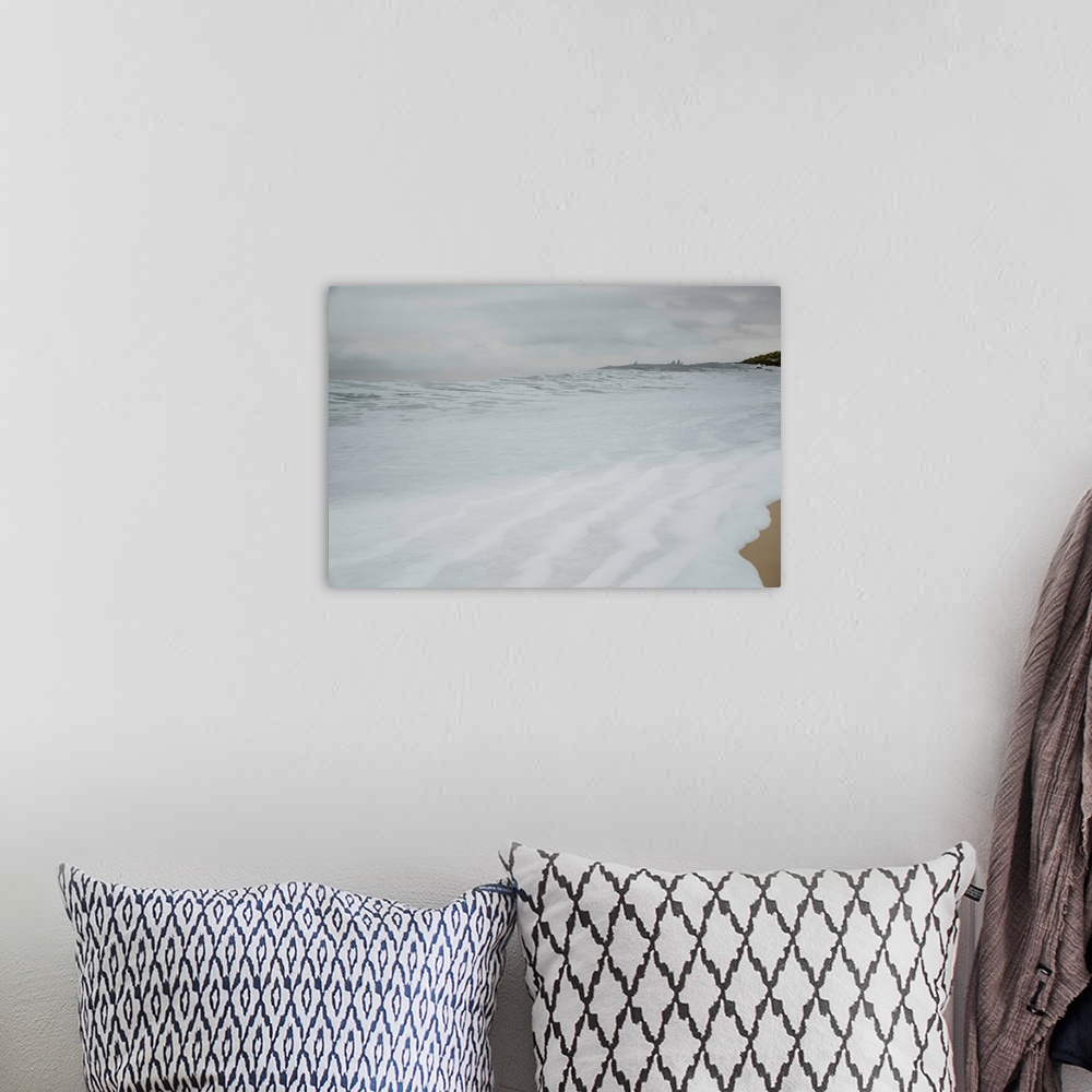 A bohemian room featuring Photograph of foamy sea water rushing up the sandy shore on a cold Winter's day.