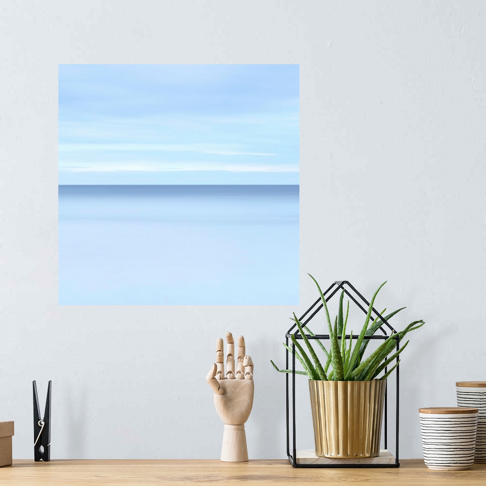 A bohemian room featuring Abstract photograph resembling a calm oceanscape with a cloudy sky.