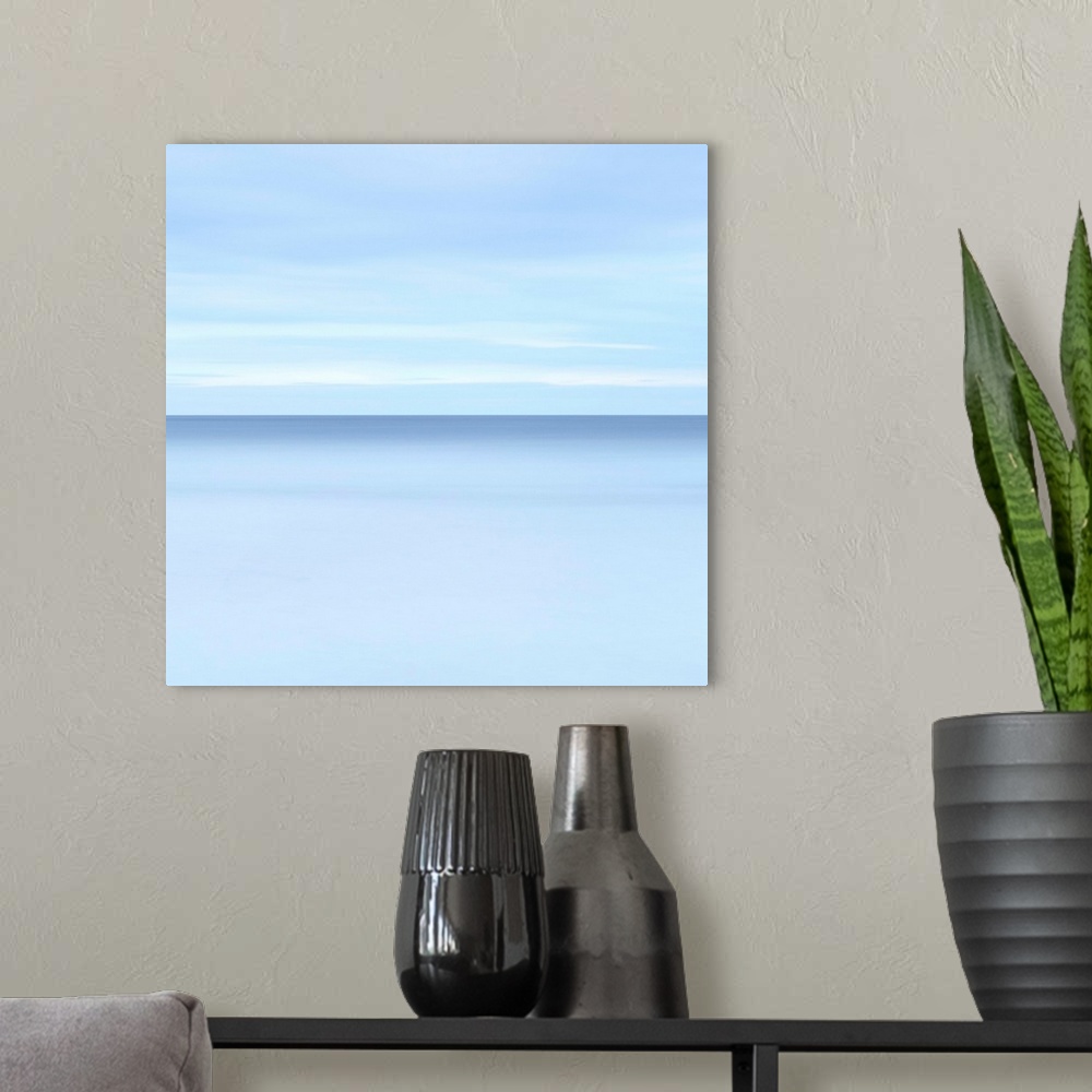 A modern room featuring Abstract photograph resembling a calm oceanscape with a cloudy sky.