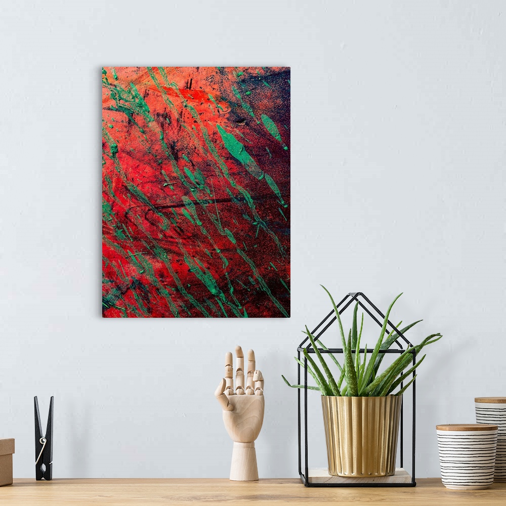 A bohemian room featuring Textured art with a bright red background with black and green strokes of color.