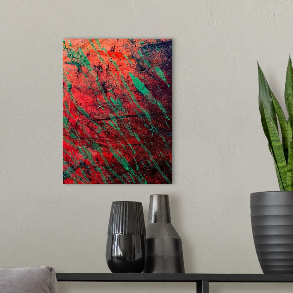 A modern room featuring Textured art with a bright red background with black and green strokes of color.