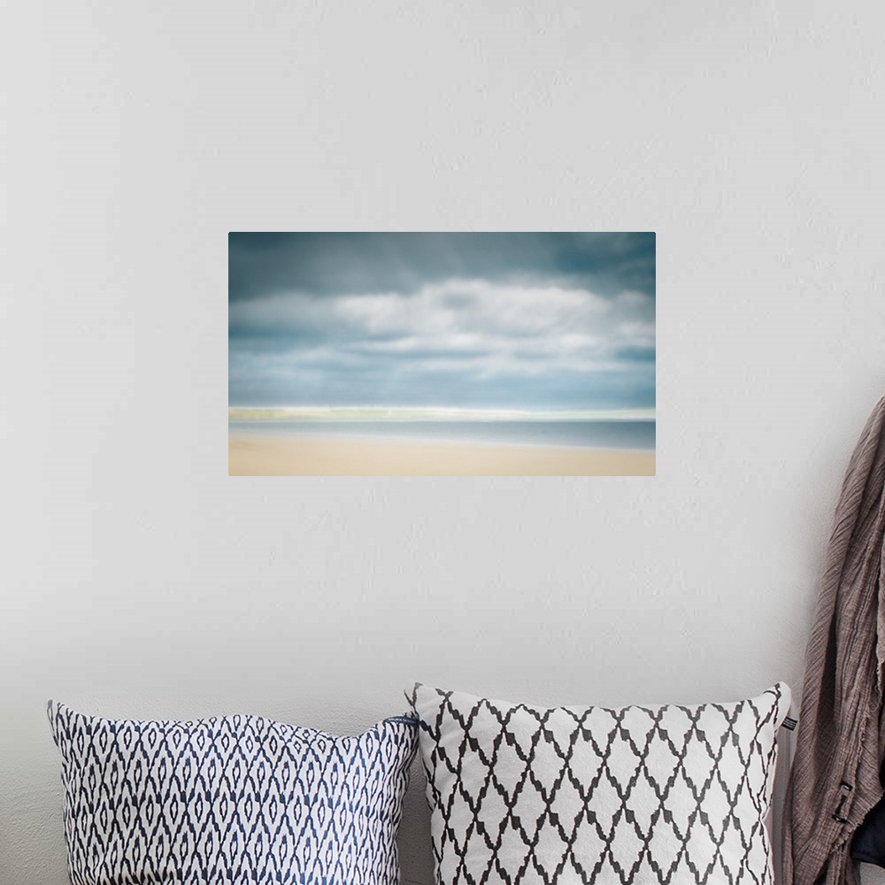 A bohemian room featuring Impressionist pastel colors of sunny day at the beach with big clouds and sand.