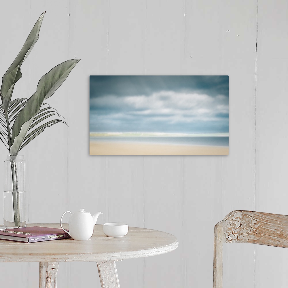 A farmhouse room featuring Impressionist pastel colors of sunny day at the beach with big clouds and sand.